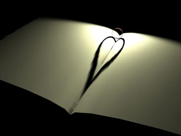 Тень сердца с кольцами на книге — стоковое фото
