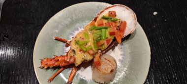 Siyah taş tabakta sebzeli haşlanmış ıstakoz. Deniz ürünleri. Üst görünüm