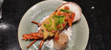 Siyah taş tabakta sebzeli haşlanmış ıstakoz. Deniz ürünleri. Üst görünüm