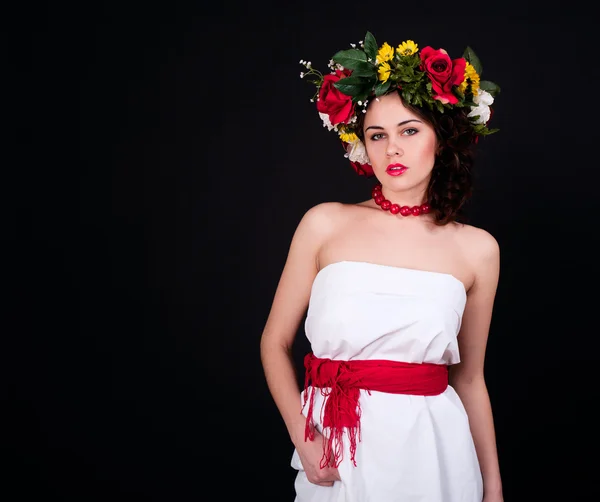 Szép nő, virág koszorú, fehér ruhában és piros káva — Stock Fotó