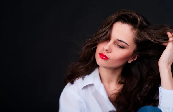 Junge Frau in blauem Hemd mit langen Haaren und halbgeschlossenen Augen — Stockfoto