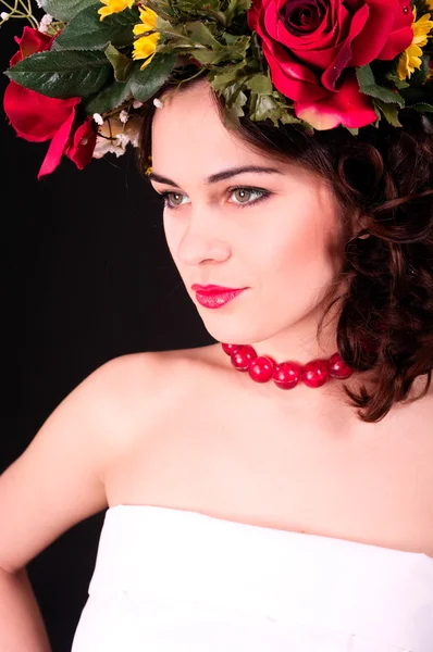 Mooie vrouw in bloem krans portret, witte jurk en rode s — Stockfoto