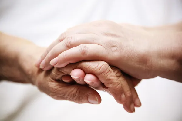 Erwachsene helfen Senior im Krankenhaus Stockfoto
