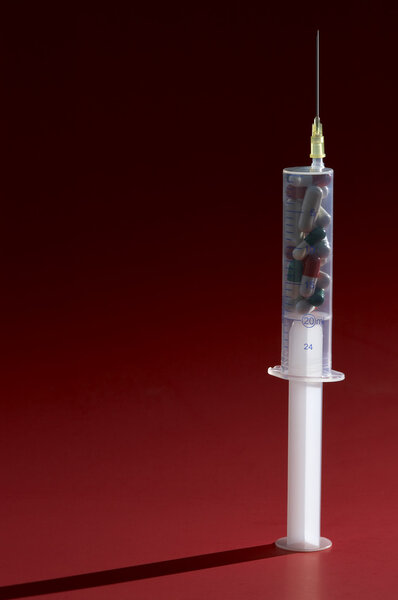 Syringe over red background