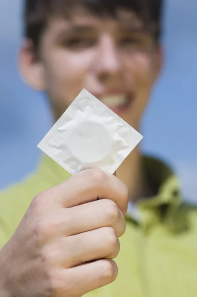 Подросток с презервативом — стоковое фото