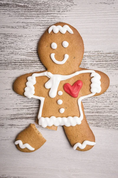 Gingerbread man with red heart and broken leg — Stock Photo, Image