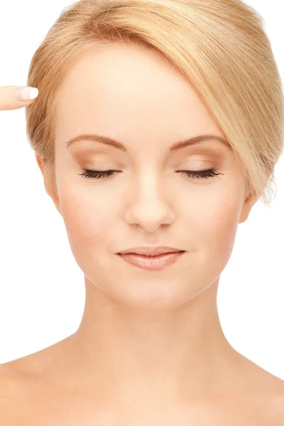 Beautiful woman pointing to forehead — Stock Photo, Image