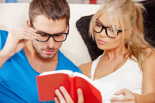 Pareja en casa con libro — Foto de Stock