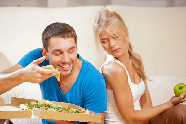 Pareja comiendo diferentes alimentos —  Fotos de Stock