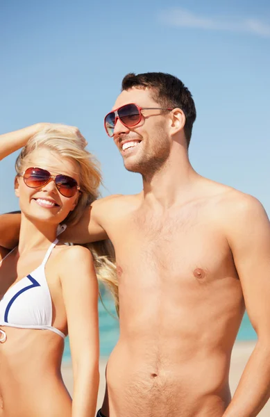 Счастливая пара в солнечных очках на пляже — стоковое фото