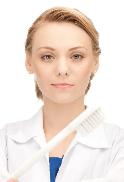 Atrakcyjna kobieta lekarz ze szczoteczka do zębów — Zdjęcie stockowe