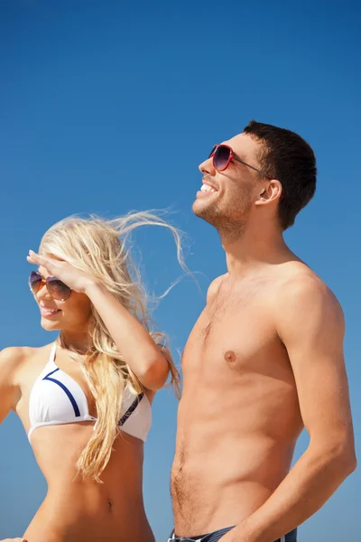 Joyeux couple en lunettes de soleil sur la plage — Photo