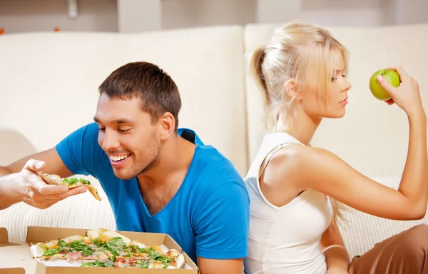 Pareja comiendo diferentes alimentos — Foto de Stock