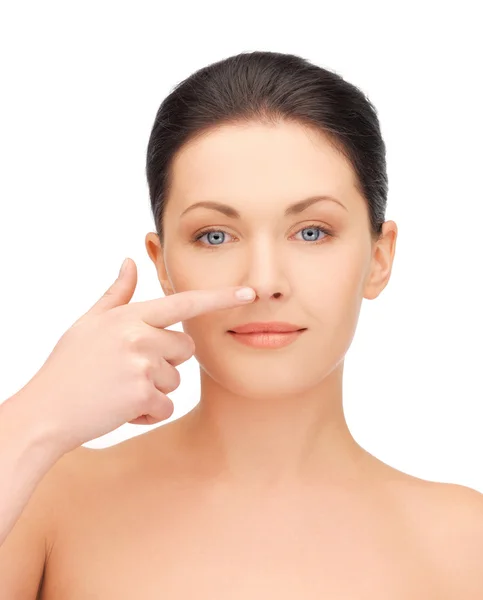 Beautiful woman pointing to nose — Stock Photo, Image