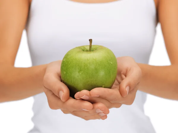 Mains féminines avec pomme verte — Photo