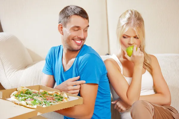 Casal comer comida diferente Imagem De Stock