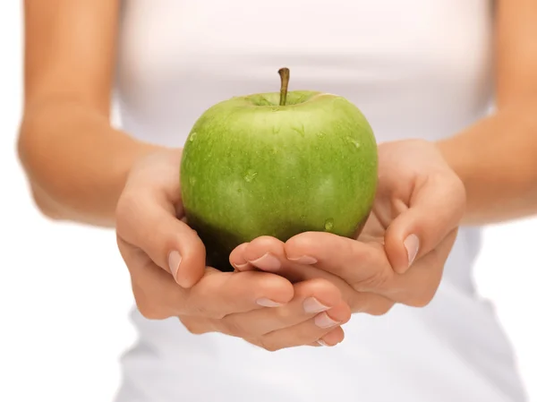 Kvinnliga händer med grönt äpple — Stockfoto