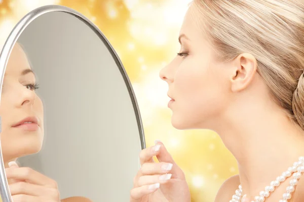 Beautiful woman with pearl beads and mirror — Stock Photo, Image