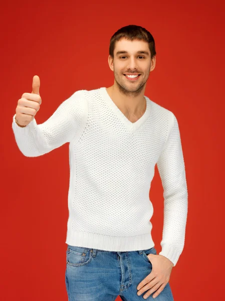 Человек в тёплом свитере показывает большие пальцы вверх — стоковое фото