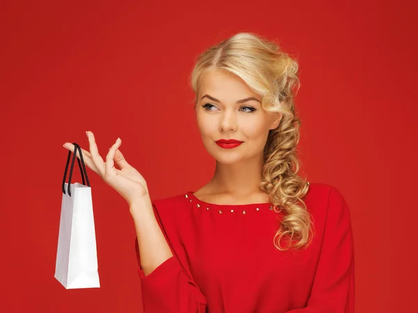 Mooie vrouw in rode jurk met boodschappentas — Stockfoto