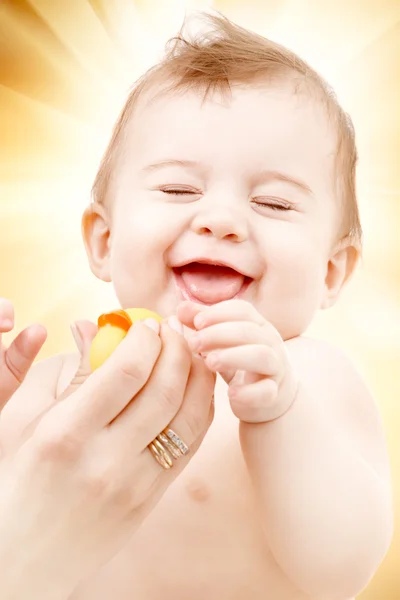 Laughing baby boy in mother hands with rubber duck — Stock Photo, Image