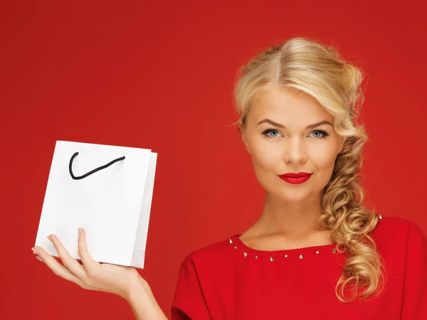 Mooie vrouw in rode jurk met boodschappentas — Stockfoto