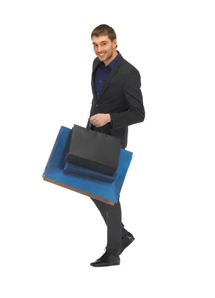 Pohledný muž v obleku s nákupní tašky — Stock fotografie