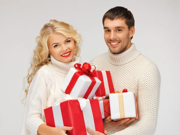Сімейна пара в светрах з подарунковими коробками — стокове фото