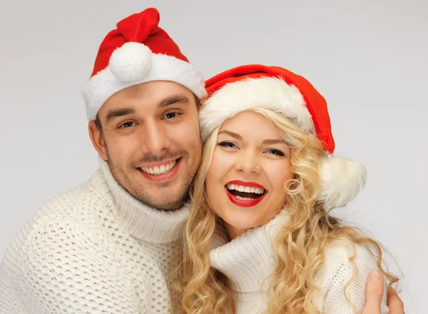 Familie paar in truien en santa's hoeden — Stockfoto