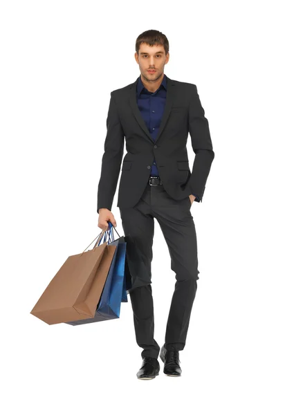 Bello uomo in giacca e cravatta con shopping bags — Foto Stock