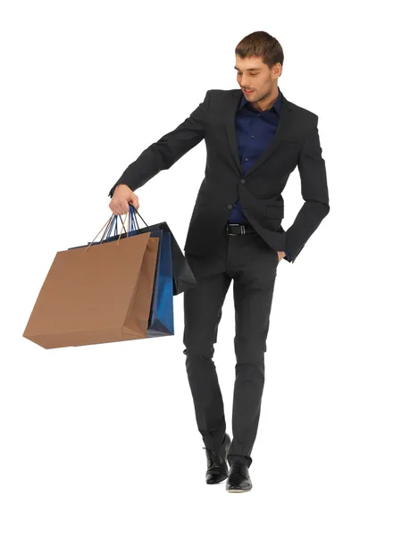 Hombre guapo en traje con bolsas de compras — Foto de Stock