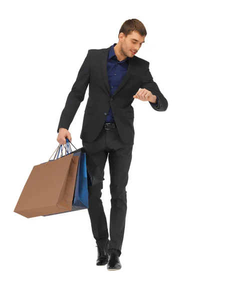 Bel homme en costume avec des sacs à provisions — Photo