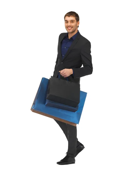 Knappe man in pak met shopping tassen — Stockfoto