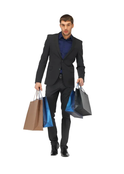 Yakışıklı erkek takım elbise ile alışveriş torbaları — Stok fotoğraf