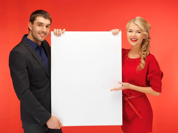 Pareja sosteniendo gran tablero en blanco — Foto de Stock