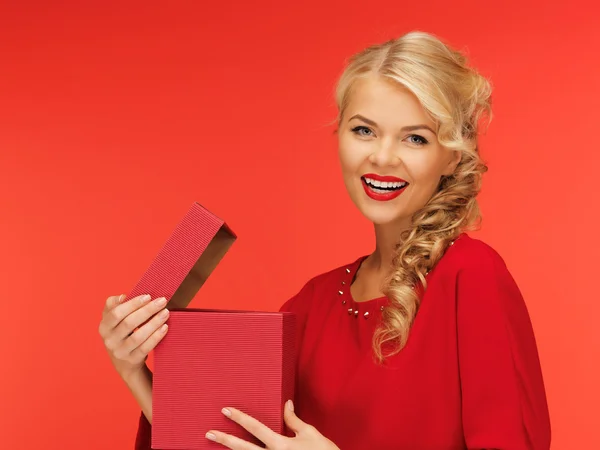 Lovely woman in red dress with opened gift box — Stock fotografie