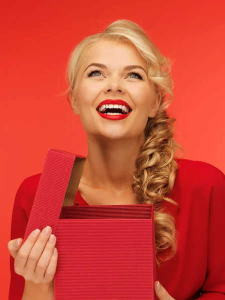 Preciosa mujer en vestido rojo con caja de regalo abierta — Foto de Stock