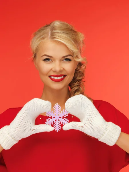 Frau in Fäustlingen und rotem Kleid mit Schneeflocke — Stockfoto