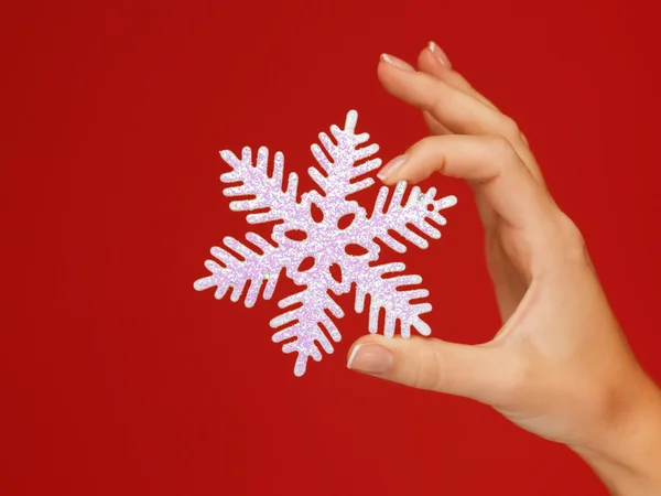 Mãos de mulher segurando um floco de neve — Fotografia de Stock