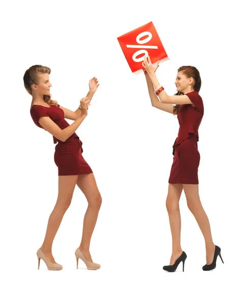 Two teenage girls in red dresses with percent sign — Stock Photo, Image