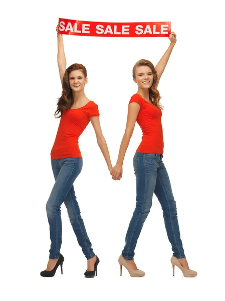 Two teenage girls with sale sign — Stock Photo, Image