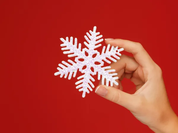 Mãos de mulher segurando um floco de neve — Fotografia de Stock