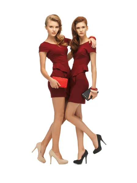 Two teenage girls in red dresses with clutches — Stock Photo, Image