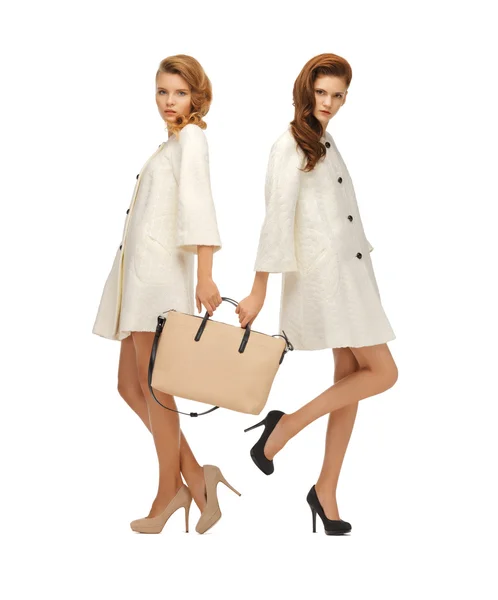 Twee tienermeisjes in witte jassen met zak — Stockfoto