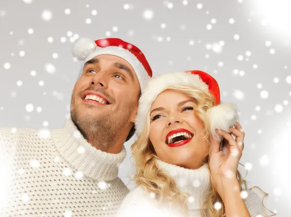 Family couple in sweaters and santa's hats — Stock Photo, Image