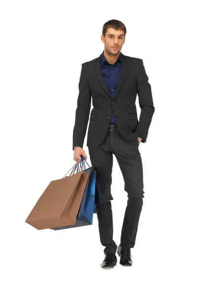 Bello uomo in giacca e cravatta con shopping bags — Foto Stock