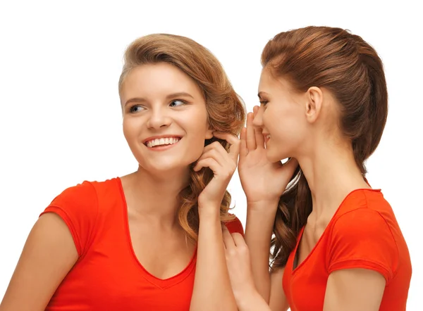 Deux adolescentes qui parlent en t-shirts rouges Images De Stock Libres De Droits