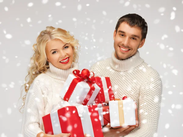 Familienpaar im Pullover mit Geschenkschachteln — Stockfoto