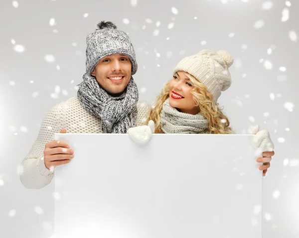 Casal em uma roupa de inverno segurando placa em branco — Fotografia de Stock