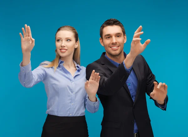 Hombre y mujer trabajando con algo imaginario — Foto de Stock